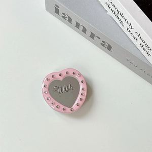 Macro shot of pink heart phone grip with mirror surface and rhinestone inlay detail