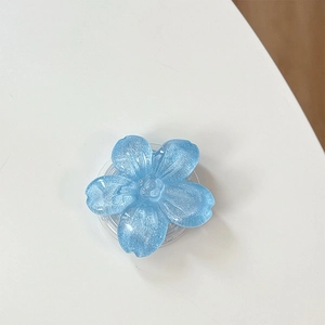 Dettaglio del supporto per telefono a forma di fiore azzurro con glitter e resina
