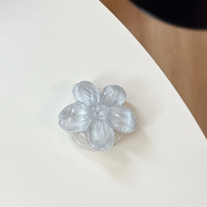 Dettaglio macro del supporto per telefono a fiore glitter argento con base retrattile retro