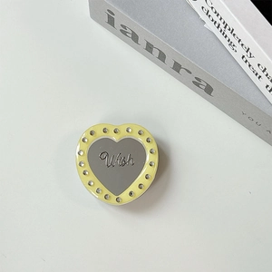 Close-up of heart-shaped magnetic phone grip with yellow rhinestones and silver mirror finish
