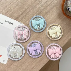 Magnetic pearl bow phone grip socket in six pastel colors on a wooden surface