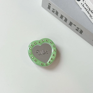 Detail of heart-shaped acrylic mirror phone stand with rhinestones and Wish lettering