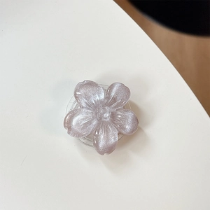 Dettaglio macro del supporto per telefono a fiore glitter viola con finitura perlata