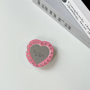Detail of pink heart-shaped magnetic phone grip with rhinestone edges and wish mirror