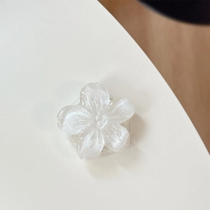 Dettaglio del supporto per telefono a fiore bianco glitterato con finitura perlata