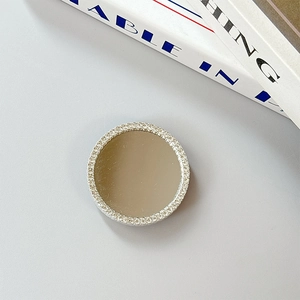 Close-up of a round silver phone socket mirror featuring a luxury rhinestone-studded border