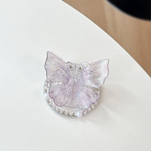 Macro shot of 3D purple iridescent butterfly phone grip with rhinestone and pearl base