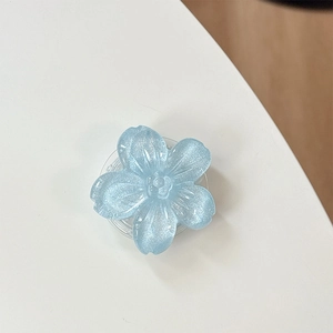 Dettaglio macro di un supporto per telefono a fiore glitter blu con petali in resina