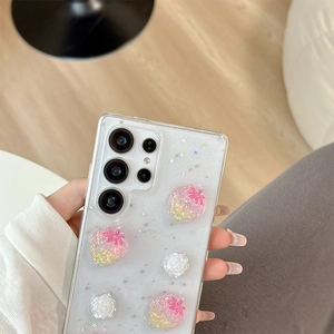 Detail view of transparent glitter phone case with 3D resin strawberry and floral decor
