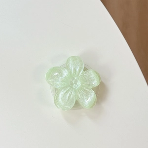 Dettaglio del supporto per telefono floreale verde chiaro con glitter e centro a stella