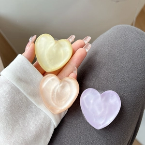 Glitter heart-shaped phone grip sockets in pastel yellow orange and purple pearlescent finish