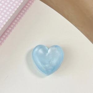 Macro shot of light blue heart-shaped phone grip with pearlescent marble texture