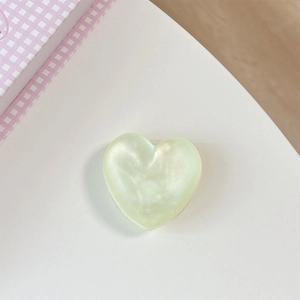 Detail of light green heart-shaped phone grip with pearlescent finish and 3D design