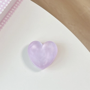 Close-up of light purple heart-shaped phone grip with marble texture and clear base