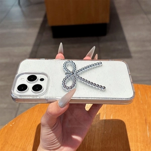 Detail of glitter iPhone case with silver beaded K letter pattern held by a hand