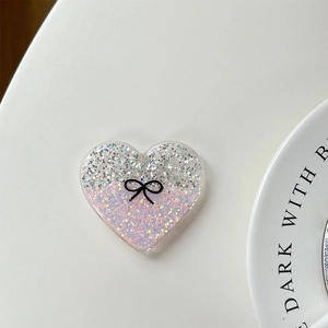 Close-up of glitter heart phone grip with pink and silver sequins and black bow detail