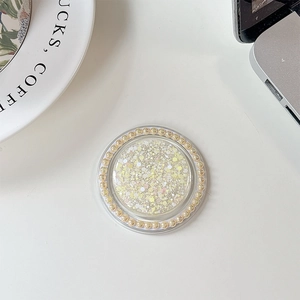 Detail view of round phone socket with yellow sequins and pearl trim on white desk