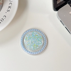 Detail of blue glitter phone socket with pearl rim on white desk with laptop corner