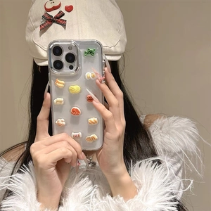 Detail of 3D food charms on transparent iPhone case featuring ramen egg and shrimp deco