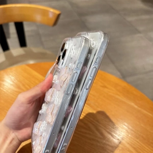 Vue détaillée de la coque iPhone transparente avec nœud 3D, perles et boutons précis