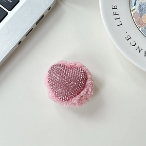 Close-up of pink heart phone grip featuring sparkling rhinestones and plush fleece texture