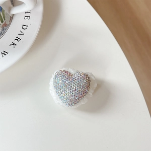 Detail of heart-shaped phone holder with colorful rhinestones and white plush base