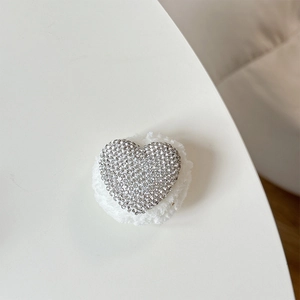 Macro shot of heart-shaped rhinestone phone grip with white plush backing details