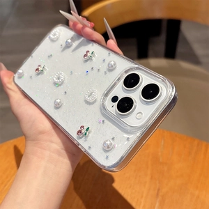 Détail de coque iPhone pailletée avec cœurs en perles 3D et décors cerises en cristal