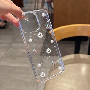 Détail de coque iPhone transparente avec motifs cerise, perles et sequins en cœur