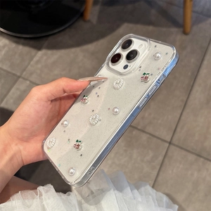 Détail de la coque iPhone transparente avec breloques cerise, perles et paillettes