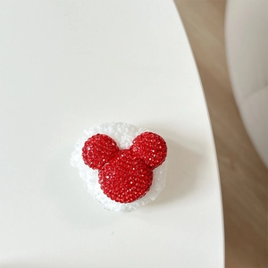 Detail of red rhinestone Mickey-shaped accessory with soft white plush fur base back