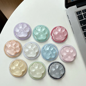 Cat paw magnetic phone grip with colorful beads in various macaron colors on a desk