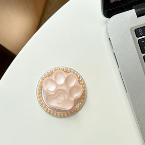Detail of pink cat paw phone grip with heart relief and gold pearl bead edging