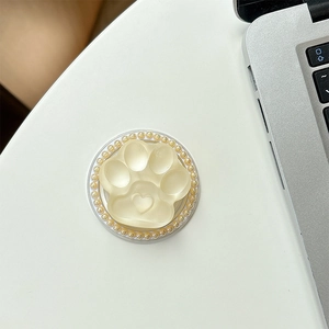 Detail of a cat paw phone socket with pearl inlay and heart relief on a desk
