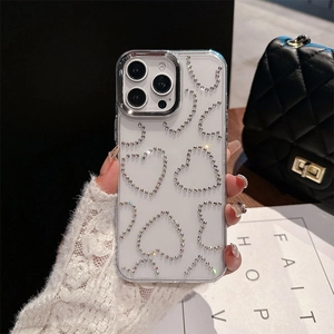 Détail d'une coque iPhone transparente avec cœurs en strass brillants et bordure caméra