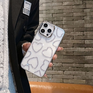 Détail macro de la coque iPhone transparente avec cœurs en strass et bordure argentée