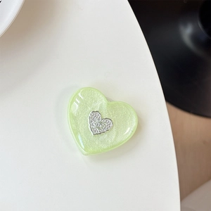 Detail of light green pearlescent heart phone socket with sparkling silver logo inlay