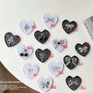 Macro detail of heart-shaped mini makeup mirrors with glitter sequins and bow charms