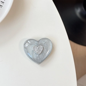 Macro shot of silver heart phone socket with glitter texture on a white table
