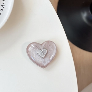Detailed view of a 3D heart-shaped phone socket featuring a metallic letter emblem