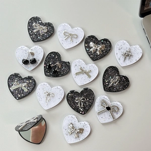 Sparkly heart-shaped portable compact mirrors with bow, cherry, and star charms in silver glitter
