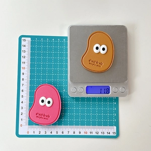 Macro shot of faux leather phone grips with cute big eyes and embossed text on scale