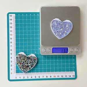 Glitter heart folding phone mirror accessory showing 4.5cm width and 13.2g weight on scale