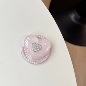 Detail eines Herz-Handyhalters mit Glitzerharz, Metall-Logo und rosa Perlenkante