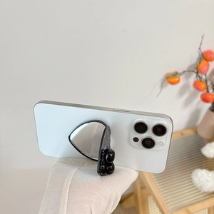 Close-up of a black multifunctional phone grip with a vanity mirror and decorative beads