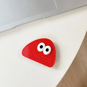 Detail of red leather triangular phone grip featuring embossed eyes and stitched edge