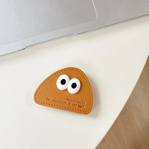 Close-up of caramel leather phone socket with big 3D eyes and textured stitching