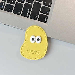 Macro detail of yellow leather phone grip showing stitched edges and embossed text