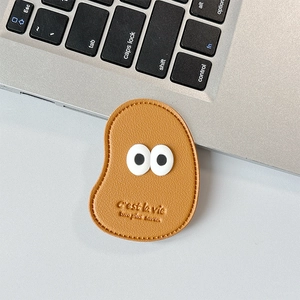 Detail of caramel leather phone socket with big eyes and C'est la vie embossed text