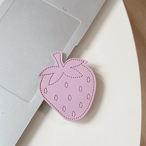 Detailed close-up of pink leather strawberry phone grip with fine stitching and soft texture